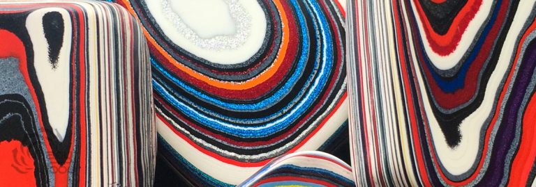 Colorful Fordite showing layered automotive paint patterns