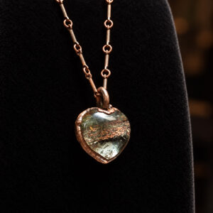 Side view of garden quartz heart pendant in copper